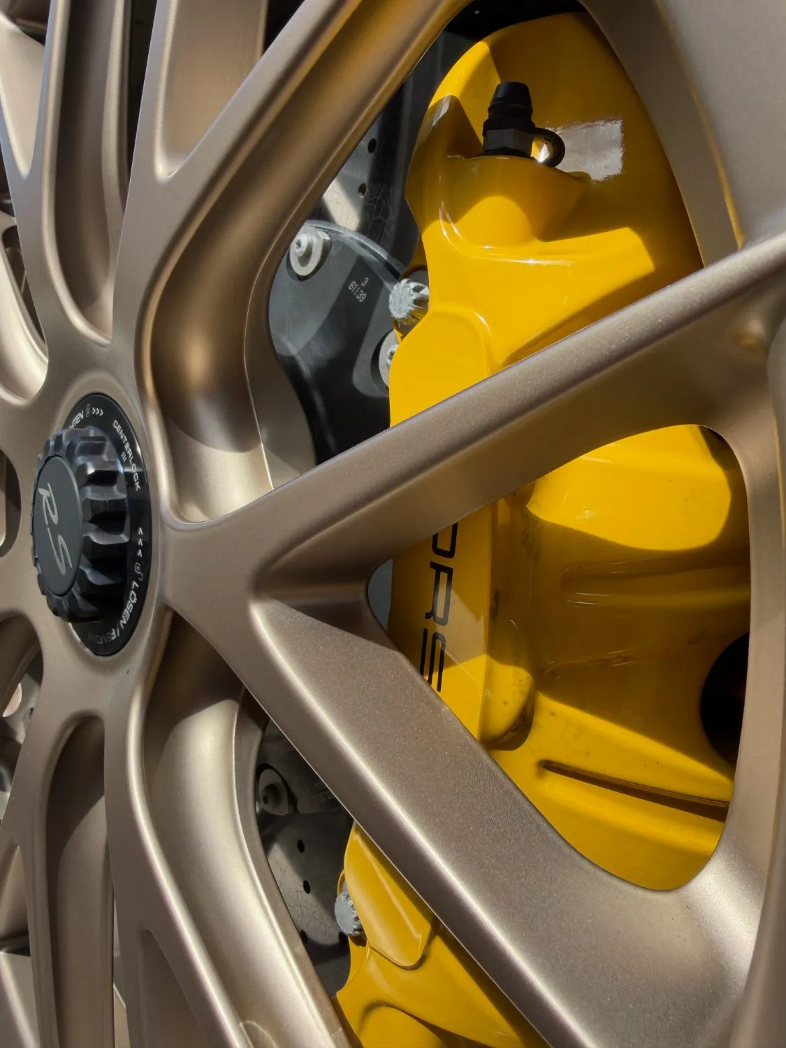 Close-up of a gold forged wheel with yellow brake caliper